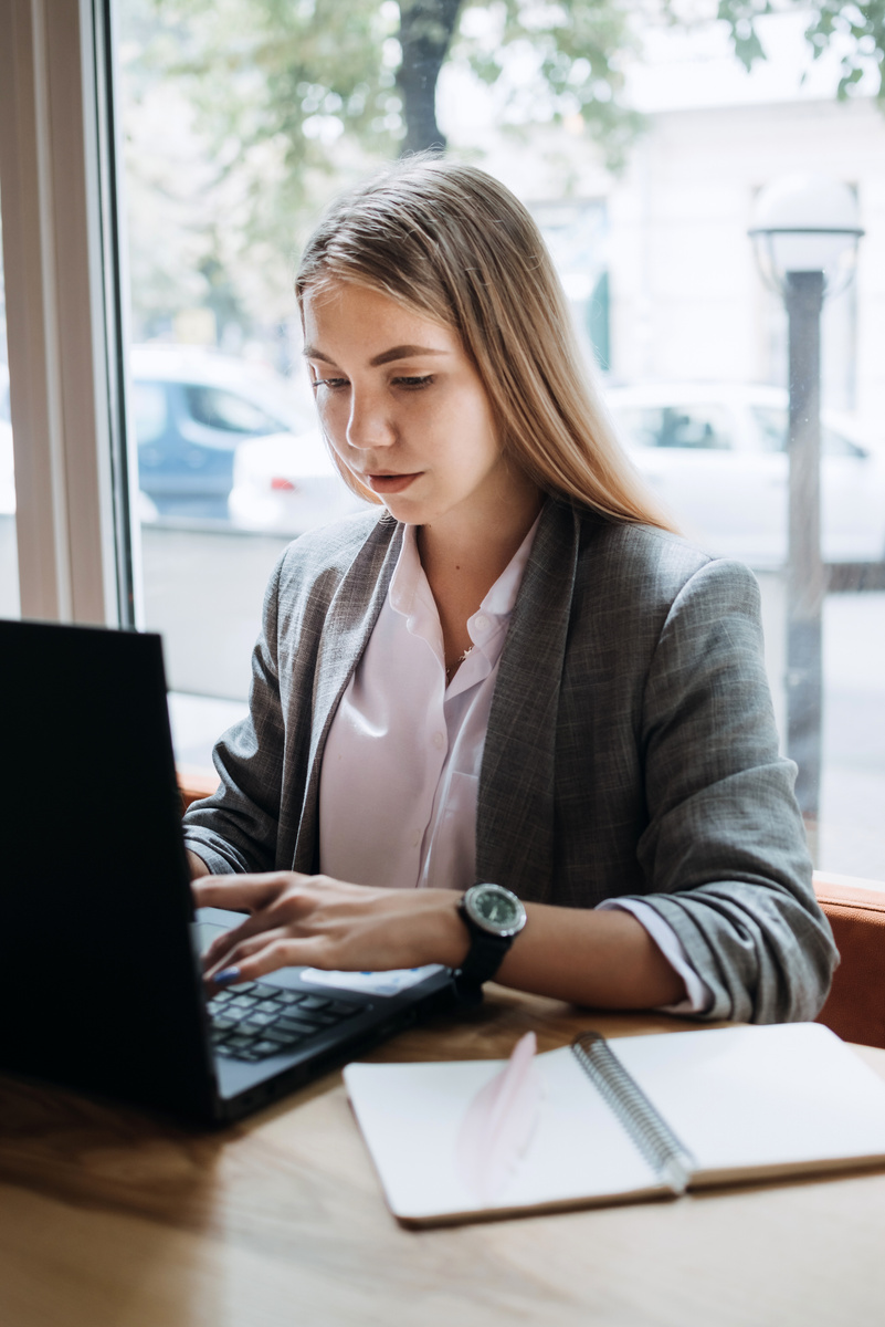 Businesswoman Working with a Laptop in the Cafe